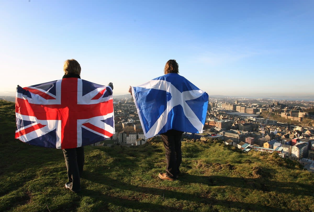 Scottish and English flags held up over Edinburgh, Scotland, as more than half of people in Scotland do not want another independence referendum next year, according to a new poll. First Minister Nicola Sturgeon has announced plans for a second vote on the issue on October 19 2023 (David Cheskin/PA) (PA Wire)