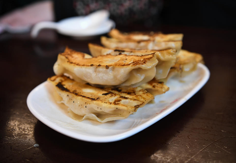 Pan fried dumplings stacked on a plate