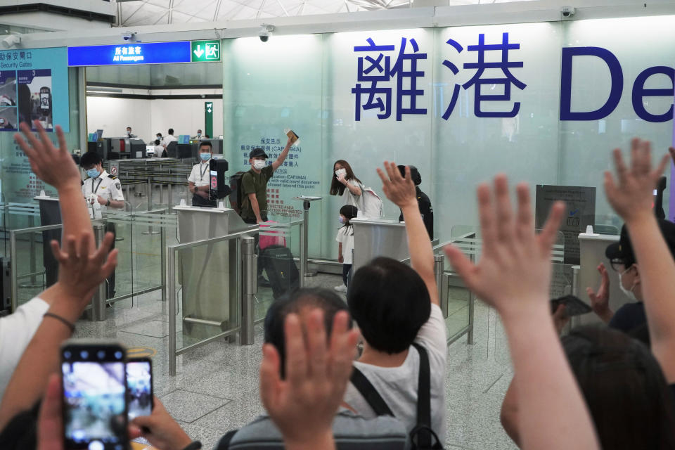 FILE - Mike Hui, rear center, farewells to his relatives and friends as he and his family prepare to leave for England, in Hong Kong airport on May 21, 2021. When the British handed its colony Hong Kong to Beijing in 1997, it was promised 50 years of self-government and freedoms of assembly, speech and press that are not allowed Chinese on the Communist-ruled mainland. As the city of 7.4 million people marks 25 years under Beijing's rule on Friday, those promises are wearing thin. Hong Kong's honeymoon period, when it carried on much as it always had, has passed, and its future remains uncertain, determined by forces beyond its control. (AP Photo/Kin Cheung, File)