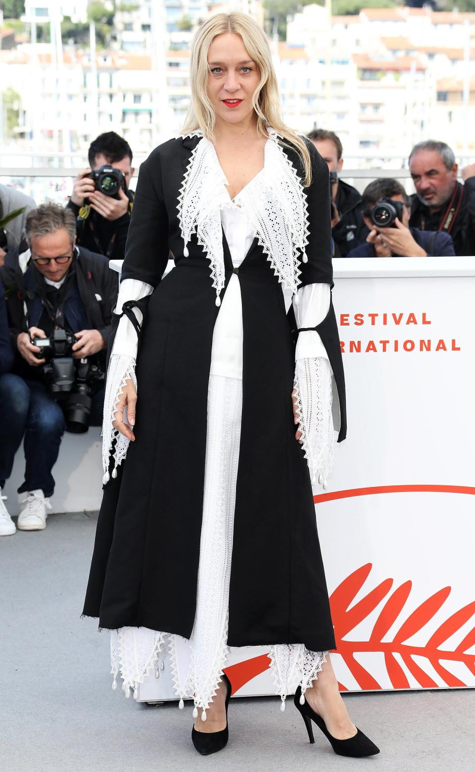 The actress wears a lace white dress with black robe on top to the photocall for <em>The Dead Don't Die</em>. 