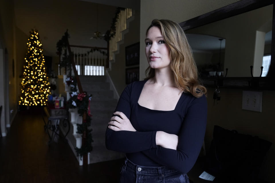 Nicole Plauché, 23, poses for a photo at her family's home in Highland Village, Texas, Friday, Dec. 15, 2023. Plauché graduated from college last year with a business degree and is navigating how to manage holiday spending while paying student loan debt. (AP Photo/LM Otero)