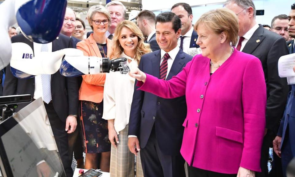 German Chancellor Angela Merkel greets a robot at the Hanover Fair in April. 