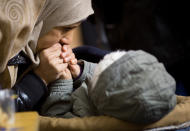 <p>Eine Mutter wärmt Anfang Januar die Hände ihres Kindes. Sie mussten wie viele andere Flüchtlinge bei frostigen Temperaturen vor dem Berliner Landesamt für Gesundheit und Soziales (LaGeSo) ausharren. (Bild: dpa) </p>