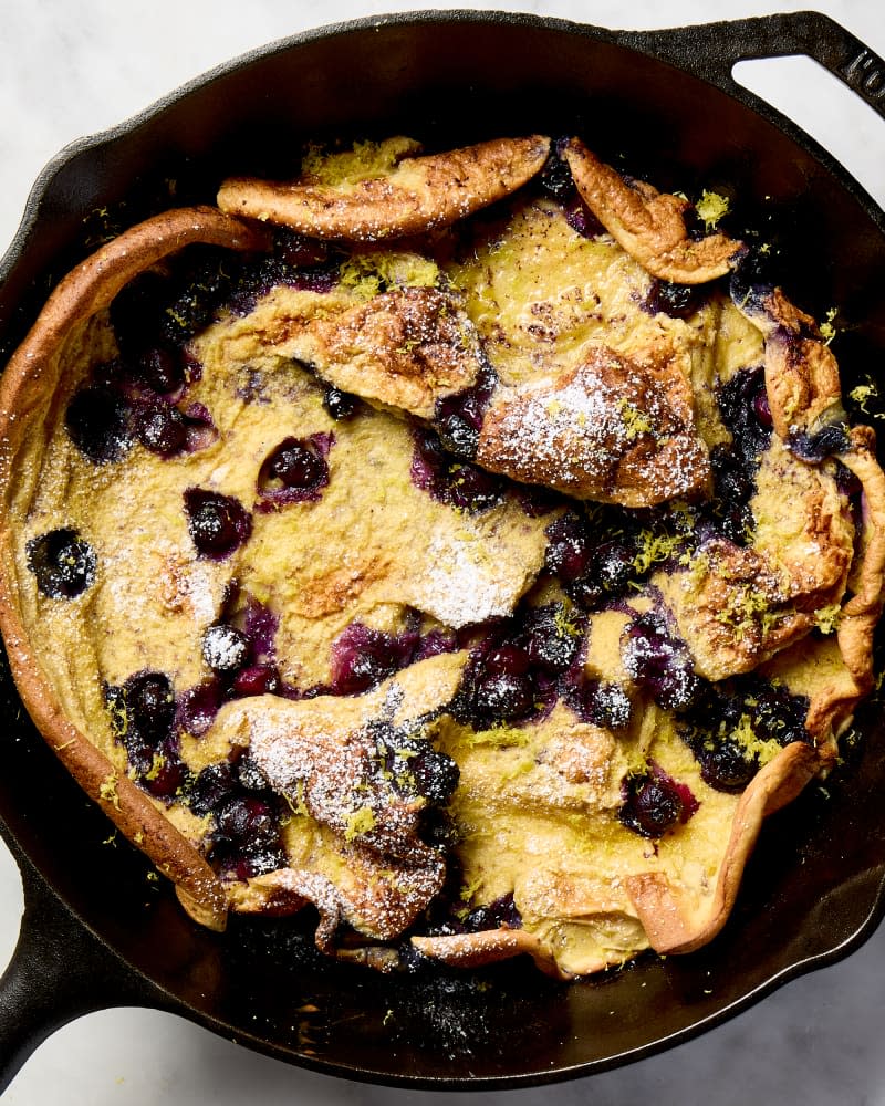 overhead shot of a lemon blueberry dutch baby pancake in a cast iron pan.