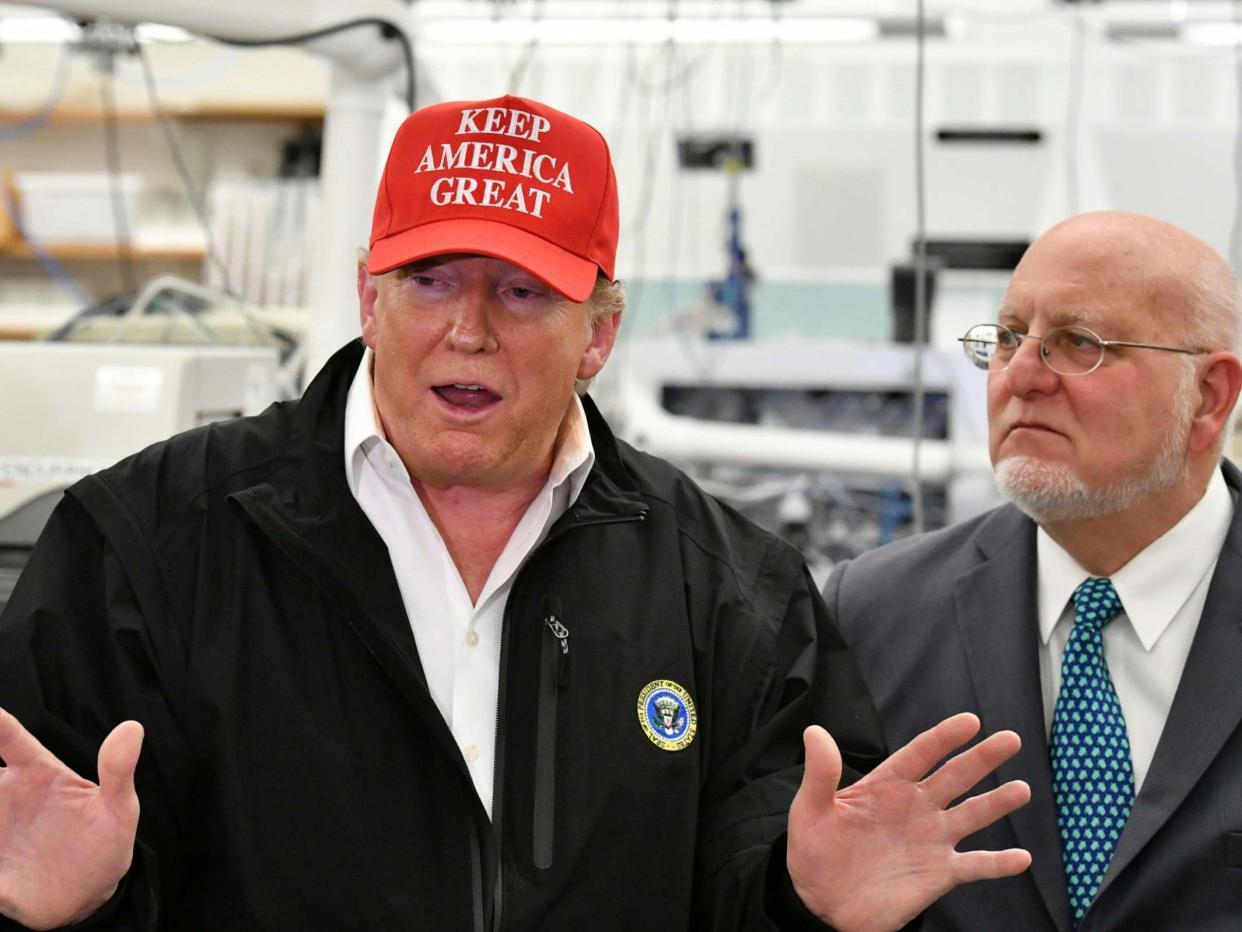 President Donald Trump speaks to members of the press as Director Robert Redfield, right, looks: AP