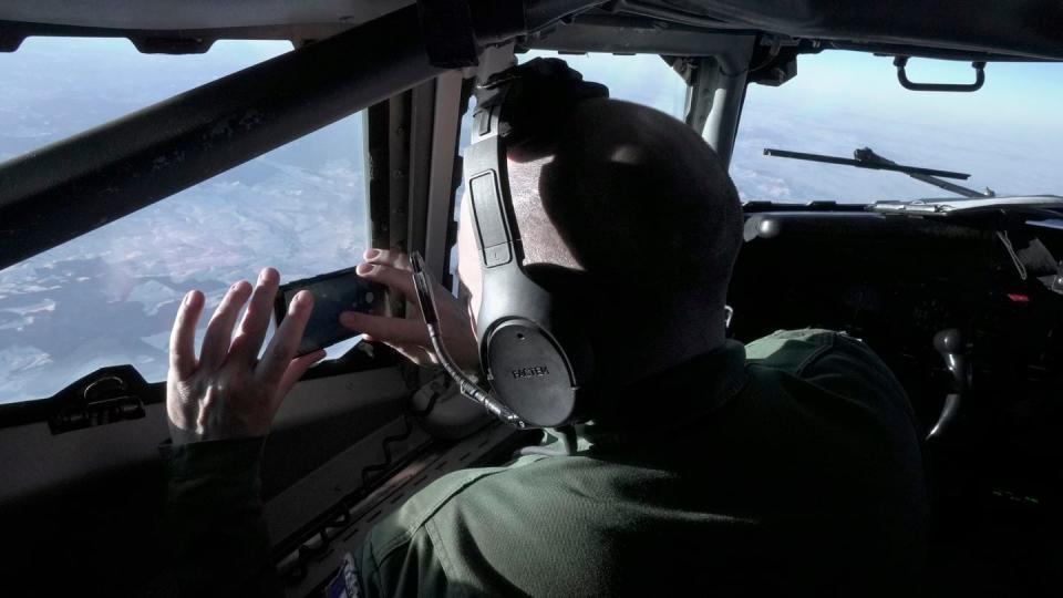 A crew member snaps a souvenir photo from the cockpit of a French military AWACS surveillance plane as it flies a 10-hour mission Tuesday, Jan. 9, 2024, to eastern Romania for the NATO military alliance. (John Leicester/AP)