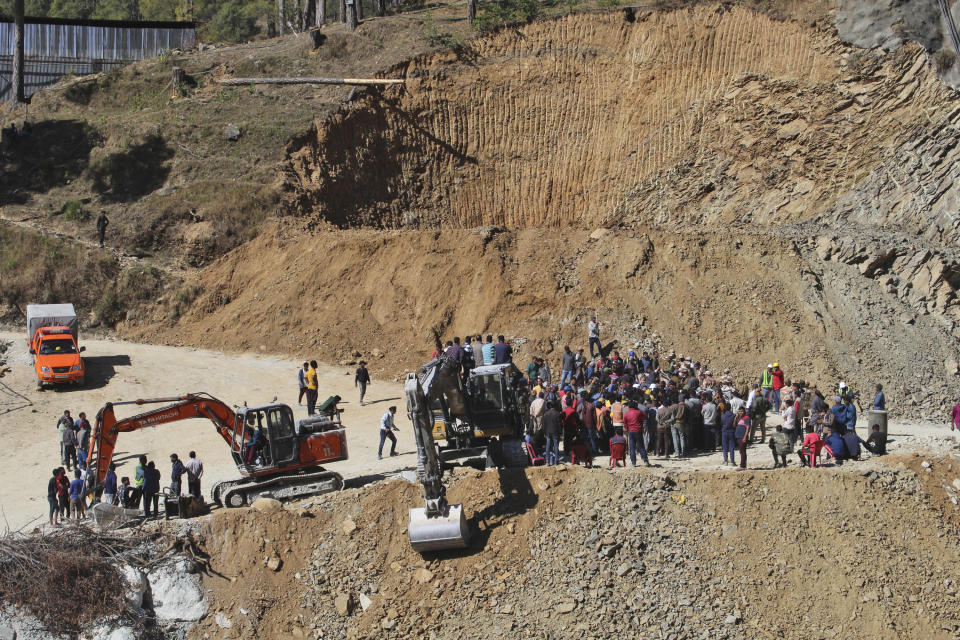 People watch rescue and relief operations at the site of an under-construction road tunnel that collapsed in mountainous Uttarakhand state, India, Wednesday, Nov. 15, 2023. Rescuers have been trying to drill wide pipes through excavated rubble to create a passage to free 40 construction workers trapped since Sunday. A landslide Sunday caused a portion of the 4.5-kilometer (2.7-mile) tunnel to collapse about 200 meters (500 feet) from the entrance. It is a hilly tract of land, prone to landslide and subsidence. (AP Photo)