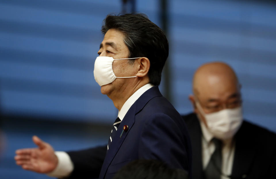 Japan's Prime Minister Shinzo Abe wears a protective mask as he enters a venue for his news conference in Tokyo, Monday, May 25, 2020. Abe is lifting a coronavirus state of emergency in Tokyo and four other remaining areas, ending the restrictions nationwide as businesses begin to reopen. (Kim Kyung-hoon/Pool Photo via AP)