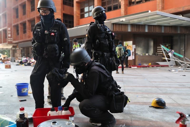 Members of a safety team established by police and local authorities arrive on campus to assess and clear unsafe items, at the Hong Kong Polytechnic University (PolyU) in Hong Kong
