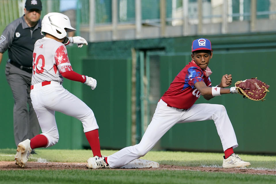 Japan's Shuma Tachibana (10) gets back to first base next to Cuba first baseman Heikel Reyes during the fourth inning of a baseball game at the Little League World Series tournament in South Williamsport, Pa., Wednesday, Aug. 16, 2023. (AP Photo/Tom E. Puskar)