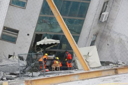 Rescue workers are seen outside a damaged building after an earthquake hit Hualien, Taiwan February 7, 2018. REUTERS/Stringer