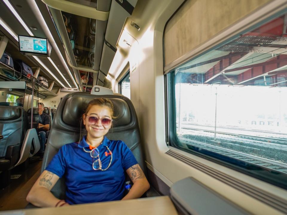 the author sits in business class on a train in Italy.