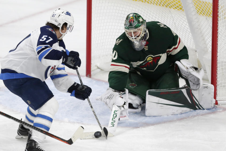 FILE - In this Jan. 4, 2020, file photo, Minnesota Wild goalie Devan Dubnyk, right, stops a shot by Winnipeg Jets left wing Gabriel Bourque in the third period of an NHL hockey game in St. Paul, Minn. Dubnyk and forward Ryan Donato were traded by the Wild to the San Jose Sharks in separate deals for draft picks on Monday, Oct. 5, 2020. (AP Photo/Andy Clayton-King, File)