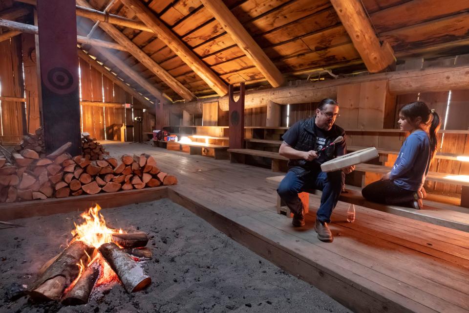 Chinook Indian Nation chairman Tony Johnson teaches a song to his daughter Maybelle, 7, as they warm up the longhouse that they built in cooperation with the National Parks Service on the Ridgefield Wildlife Refuge.