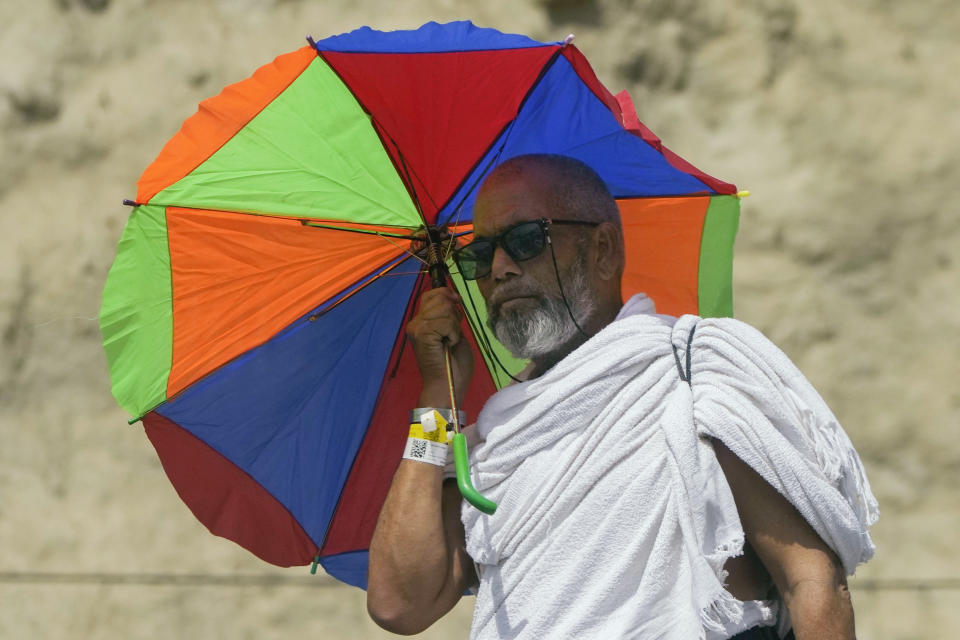 A Muslim pilgrim holds an umbrella as he walks to cast stones at a pillar in the symbolic stoning of the devil, the last rite of the annual Hajj, in Mina, near the holy city of Mecca, Saudi Arabia, Wednesday, June 28, 2023. Around two million pilgrims are converging on Saudi Arabia's holy city of Mecca for the largest Hajj since the coronavirus pandemic severely curtailed access to one of Islam's five pillars. (AP Photo/Amr Nabil)