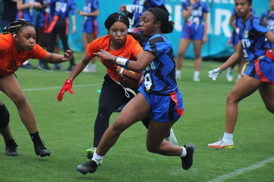 Stanton's Courtney Brown sidesteps a flag pull from Tallahassee FAMU DRS defenders at the Jaguars Prep Girls Flag Football Preseason Classic.