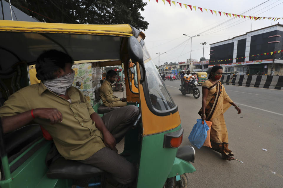 An auto rickshaw driver with his face covered as a precaution against COVID-19 waits for passengers in Bengaluru, capital of the southern Indian state of Karnataka, Thursday, Dec. 2, 2021. India on Thursday confirmed its first cases of the omicron coronavirus variant in two men in Karnataka who came from abroad. (AP Photo/Aijaz Rahi)