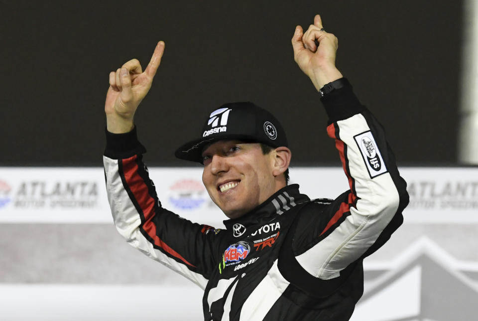 FILE - In this Feb. 23, 2019, file photo ,Kyle Busch celebrates after winning the NASCAR Truck Series auto race at Atlanta Motor Speedway in Hampton, Ga. Busch says, “Bring it on.” Chase Elliott and Kyle Larson are the latest topflight drivers to accept the challenge of Kevin Harvick, who has offered half of a $100,000 bounty to any Cup Series driver who can beat the versatile Busch in a Truck Series race this year. (AP Photo/John Amis, File)