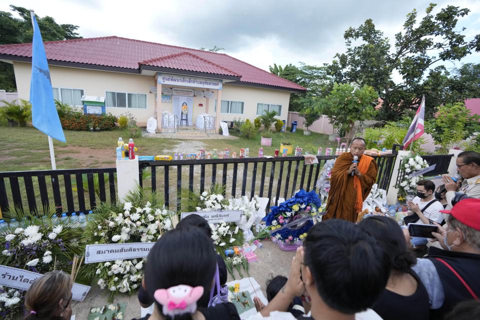 Buddhist pray with relatives of the victims of a mass killing attack gather for a Buddhist ceremony front on the Young Children's Development Center in the rural town of Uthai Sawan, north eastern Thailand, Sunday, Oct. 9, 2022. Thai police are investigating a report that a CNN crew inappropriately entered the daycare center where more than 20 preschoolers were slain as they were reporting on the attack, authorities said Sunday. (AP Photo/Sakchai Lalit)