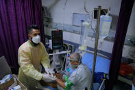 A coronavirus patient receives treatment at a hospital in Najaf, Iraq, Wednesday, July 14, 2021. Infections in Iraq have surged to record highs amid a third wave spurred by the more aggressive delta variant, and long-neglected hospitals suffering the effects of decades of war are overwhelmed with severely ill patients. (AP Photo/Anmar Khalil)