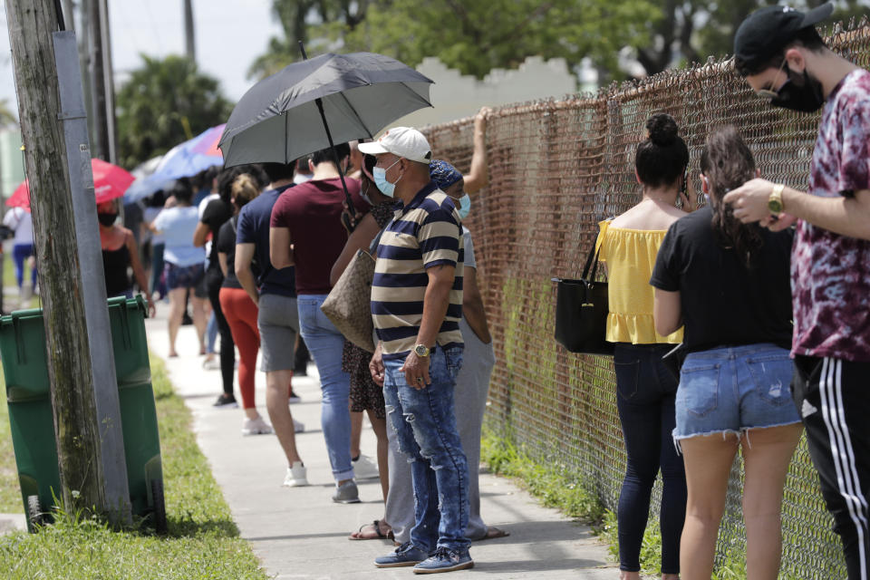 People wait in line outside of a COVID-19 testing site during the coronavirus pandemic, Thursday, July 16, 2020, in Opa-locka, Fla. (AP Photo/Lynne Sladky)