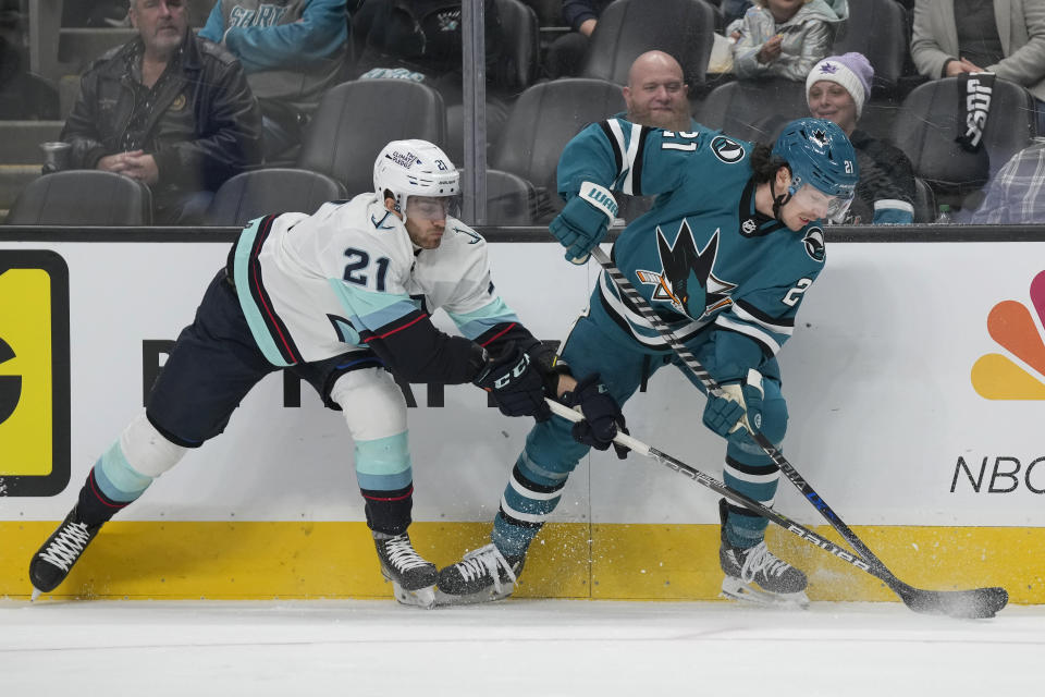 San Jose Sharks center Michael Eyssimont, right, reaches for the puck next to Seattle Kraken center Alex Wennberg during the first period of an NHL hockey game in San Jose, Calif., Monday, Feb. 20, 2023. (AP Photo/Jeff Chiu)