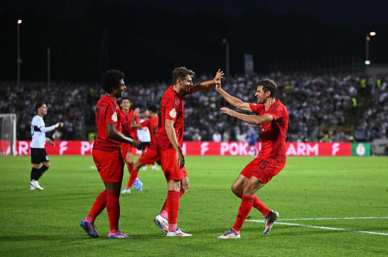 Munich's Thomas Müller celebrates his team's first goal with his teammates during the DFB Cup match between SSV Ulm 1846 and Bayern Munich at the Donaustadion. Tom Weller/dpa