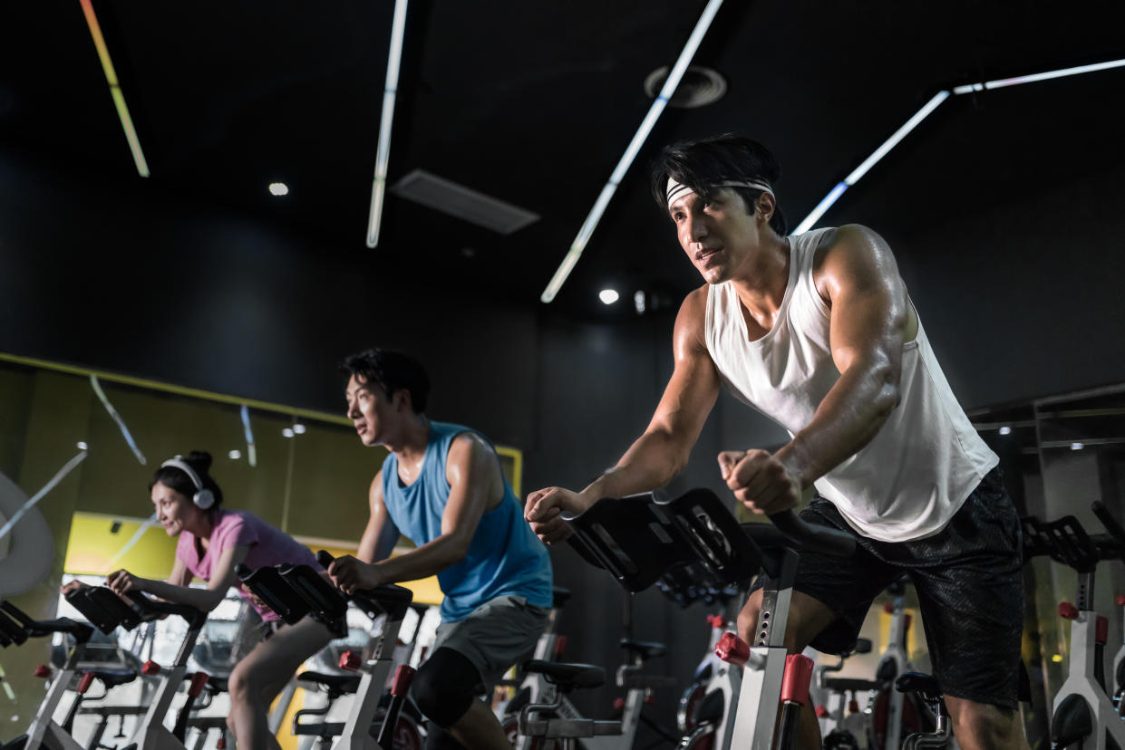 Young people riding stationary bike during indoor cycling class in gym.  PHOTO: Getty Images