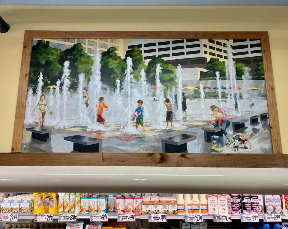 A mural of children playing in the Crown Center Fountains decorates the dairy section in the Ward Parkway Trader Joe’s. Painted by artist Mark Fetty, the painting was completed around 2011, just before the fountains closed to visitors in June 2012. Feb. 27, 2024. Eleanor Nash/enash@kcstar.com