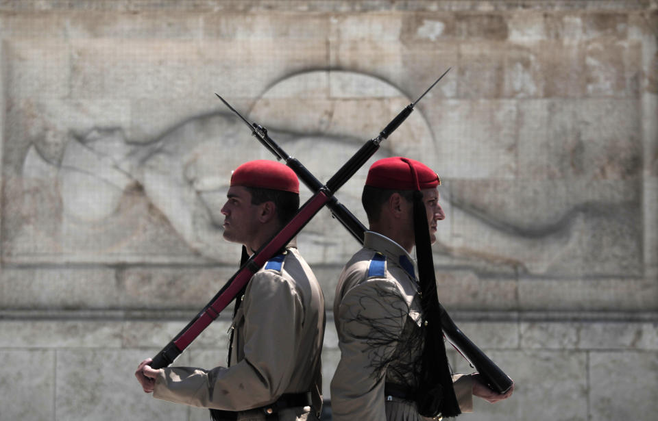 Greek presidential guards stand during the changing of the guards ceremony outside the Greek parliament in central Athens, Monday, July 9, 2012. A deputy labor minister has resigned from Greece's new coalition government, saying it should have pressed harder to renegotiate the terms of the country's bailout agreements. Nikos Nikolopoulos announced his resignation Monday, hours after the new conservative-led government won a confidence vote in parliament. (AP Photo/Dimitri Messinis)