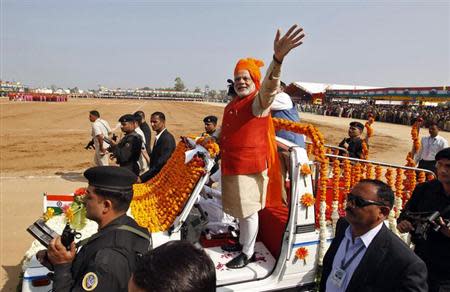 Narendra Modi waves after hoisting an Indian national flag during the Republic Day celebrations at Himmatnagar town, about 69 km east from Ahmedabad, January 26, 2014. REUTERS/Amit Dave/Files