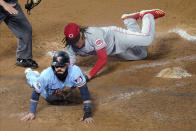 Minnesota Twins' Marwin Gonzalez, left, scores on a wild pitch by Cincinnati Reds' Luis Castillo, right, who covers the plate during the fourth inning of a baseball game Saturday, Sept. 26, 2020, in Minneapolis. The Twins won 7-3, with Castillo taking the loss. (AP Photo/Jim Mone)