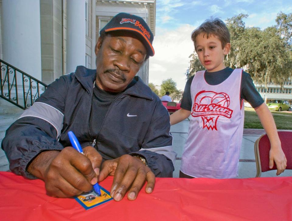 Ken Riley signs an autograph for Max Rowe, 8, from Lakeland during the opening of "Polk's Pigskin History," an exhibit at the Polk Historical Museum in Bartow in January 2009.