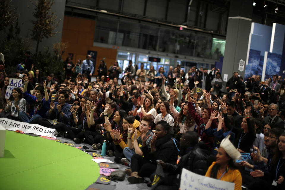 People shout slogans during a march organized by the Fridays for Future international movement of school students at the COP25 climate talks congress in Madrid, Spain, Friday, Dec. 13, 2019. The United Nations Secretary-General has warned that failure to tackle global warming could result in economic disaster. (AP Photo/Manu Fernandez)