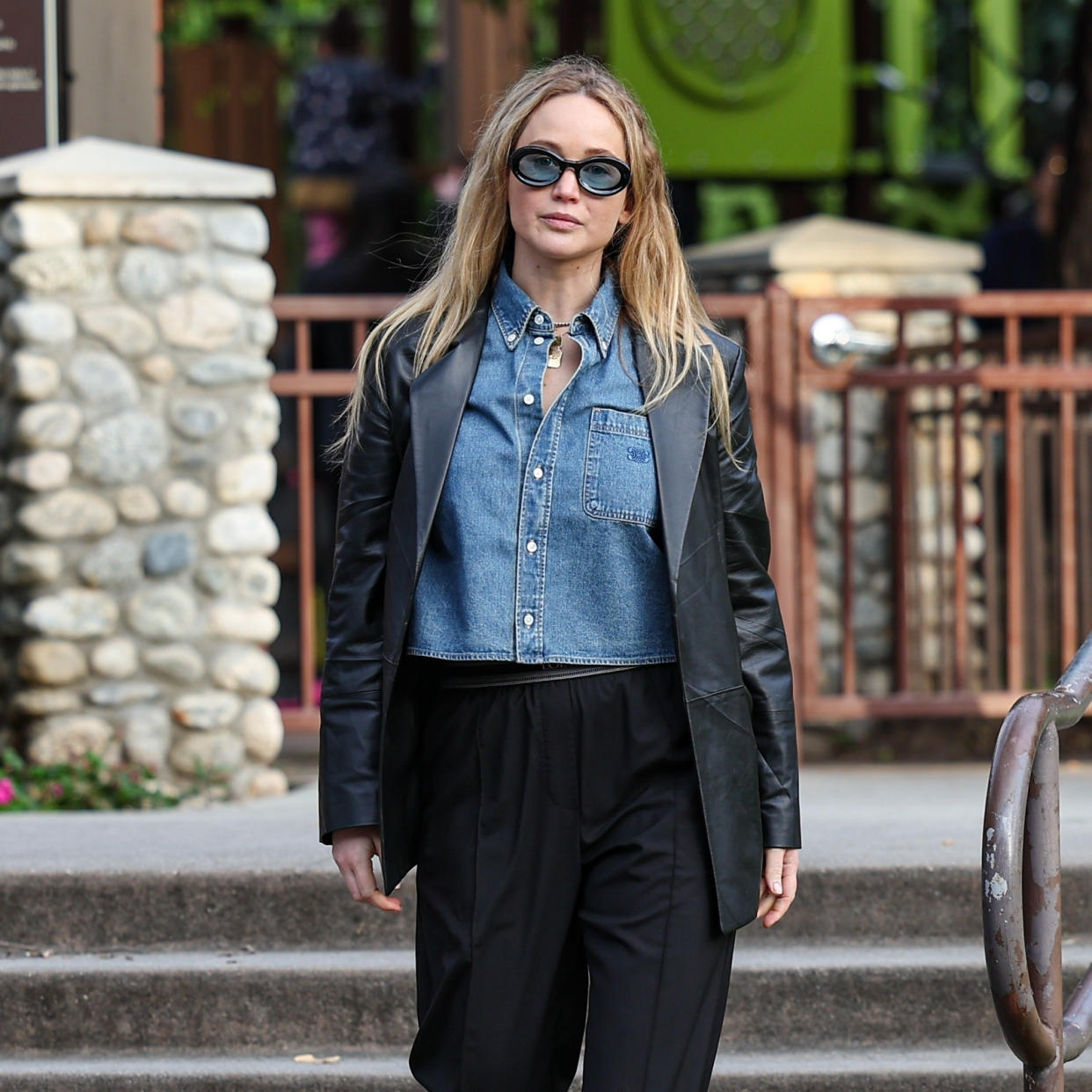  Jennifer Lawerence Wearing a denim shirt with a leather blazer and blue-tinted sunglasses. 