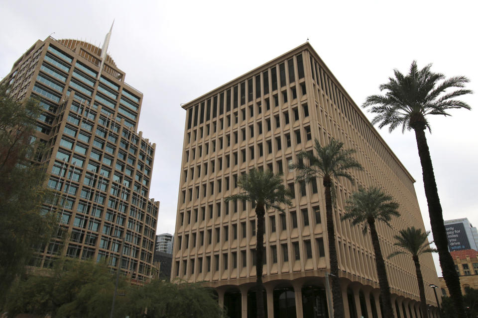 The Calvin C. Goode Municipal Building, right, stands adjacent to Phoenix City Hall, left, on Thursday, Dec. 24, 2020. The building was renamed after Goode when he retired from the City Council after 22 years, including two years as vice mayor. Phoenix city officials, residents and prominent members of the Black community will honor the late civil rights icon, city leader and longtime Arizona resident in the coming weeks. The events follow a public, open-casket viewing hosted on Saturday, Jan. 9, 2021, outside of the former city hall, renamed after Goode. (AP Photo/Cheyanne Mumphrey)