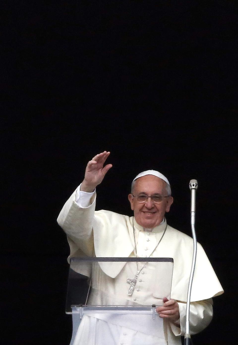 Pope Francis waves as he leads the Angelus prayer from the window of the Apostolic palace in Saint Peter's Square at the Vatican