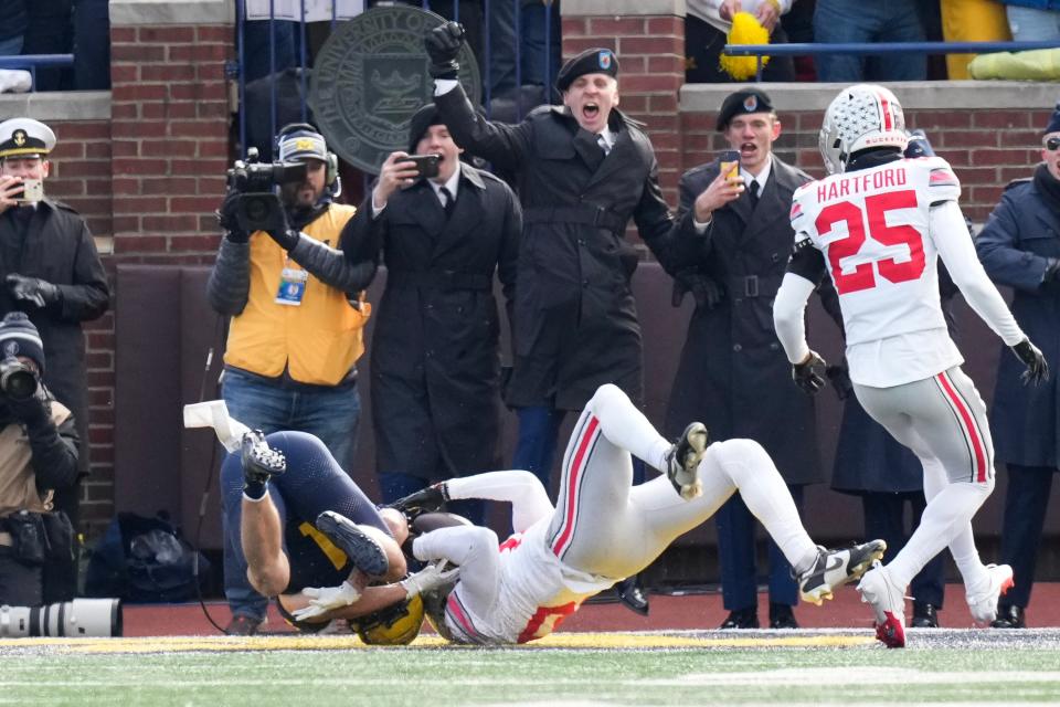 Michigan receiver Roman Wilson and Ohio State cornerback Denzel Burke vie for a ball in the end zone on a Wolverines touchdown.