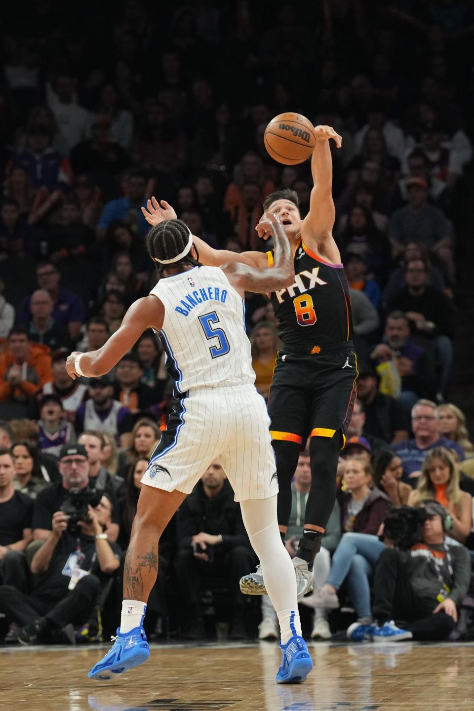 Phoenix Suns guard Grayson Allen (8) defends against Orlando Magic forward Paolo Banchero (5) during the first half at Footprint Center in Phoenix on Dec. 31, 2023.