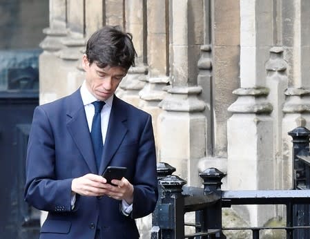 Britain's Secretary of State for International Development Rory Stewart checks his phone outside Houses of Parliament in London