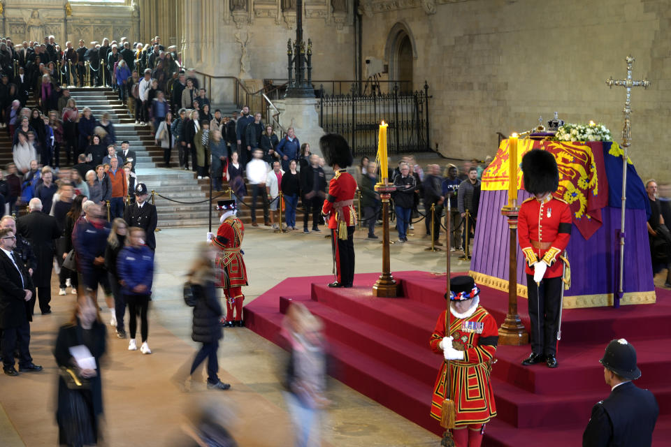 Members of the public file past the coffin of Queen Elizabeth II, draped in the Royal Standard with the Imperial State Crown and the Sovereign's orb and sceptre, lying in state on the catafalque, in Westminster Hall, at the Palace of Westminster, in London, Friday, Sept. 16, 2022, ahead of her funeral on Monday. (AP Photo/Kirsty Wigglesworth, Pool)