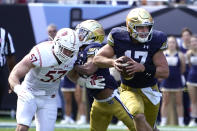 Notre Dame quarterback Jack Coan, right, scrambles away from pressure by Wisconsin linebacker Jack Sanborn during the first half of an NCAA college football game Saturday, Sept. 25, 2021, in Chicago. (AP Photo/Charles Rex Arbogast)