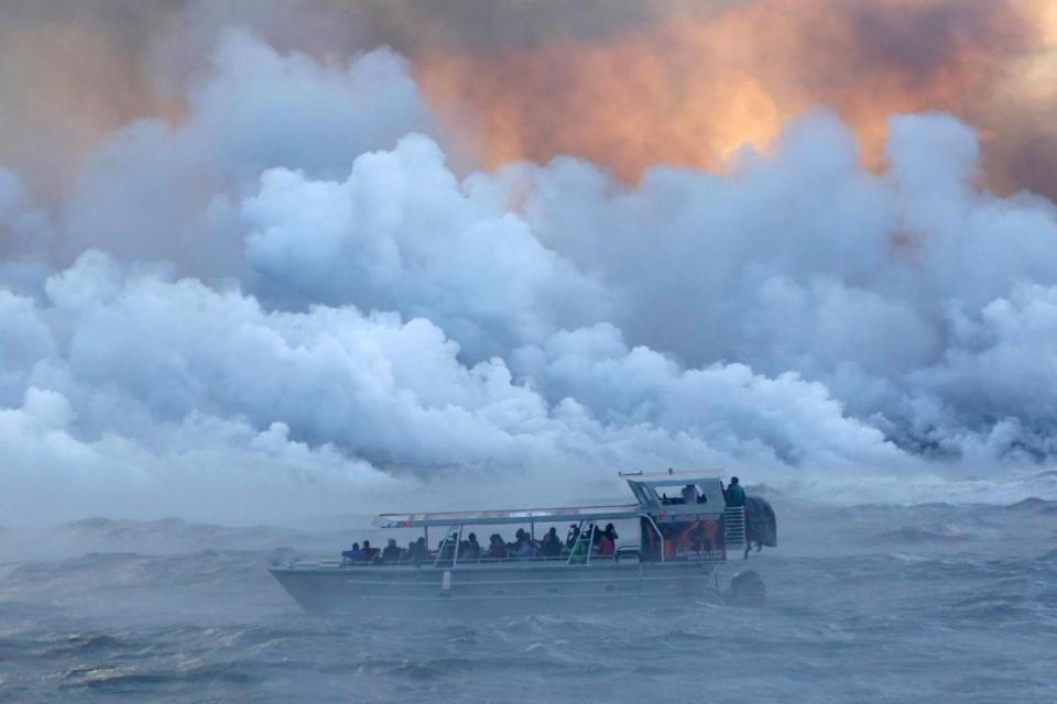 People watch from a tour boat as lava flows into the Pacific Ocean in Hawaii (file image) (REUTERS)