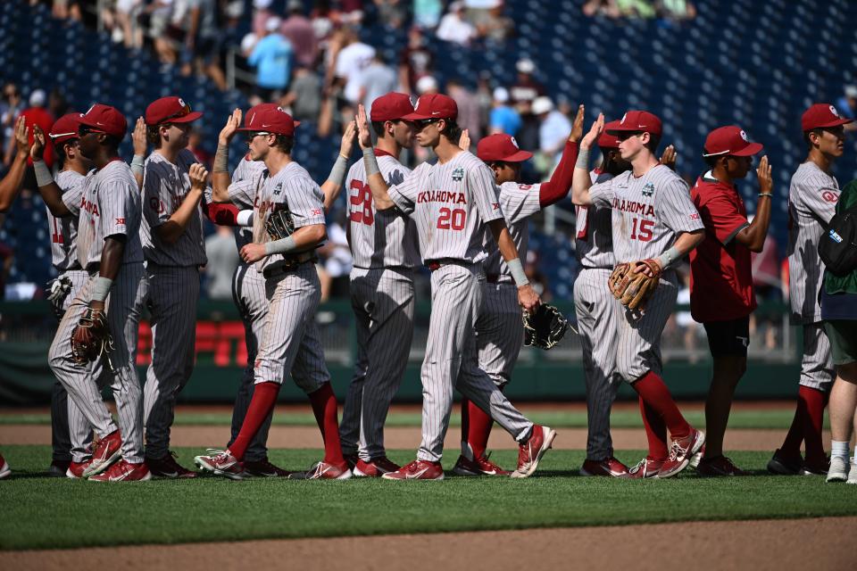 Jun 17, 2022; Omaha, NE, USA; Oklahoma Sooners shortstop Peyton Graham (20) and second baseman Jackson Nicklaus (15) celebrate the win against the Texas A&M Aggies with teammates at Charles Schwab Field. Steven Branscombe-USA TODAY Sports