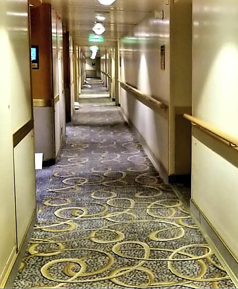 In this photo provided by Michele Smith, an empty hallway on the Grand Princess cruise ship Friday, March 6, 2020, off the California coast. Scrambling to keep the coronavirus at bay, officials ordered a cruise ship with about 3,500 people aboard to stay back from the California coast until passengers and crew can be tested, after a traveler from its previous voyage died of the disease and at least two others became infected. A Coast Guard helicopter lowered test kits onto the 951-foot (290-meter) Grand Princess by rope as the vessel lay at anchor off Northern California, and authorities said the results would be available on Friday, March 6, 2020. Princess Cruise Lines said fewer than 100 people aboard had been identified for testing. (Michele Smith via AP)