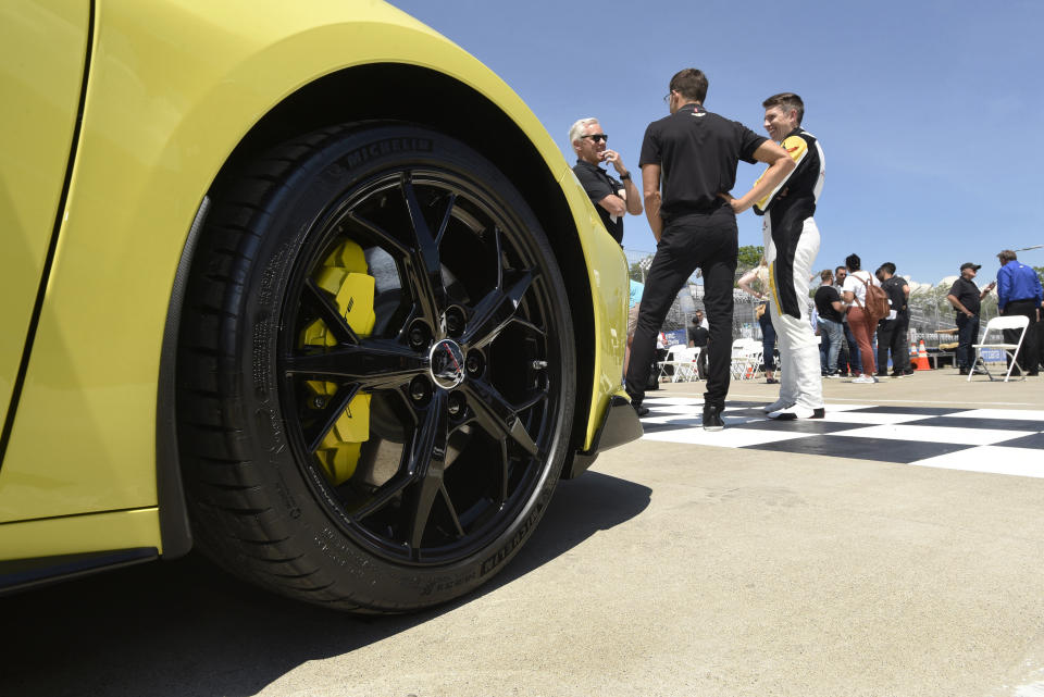 Driver Tommy Milner, right foreground, talks with General Motors personnel following a news conference at Raceway at Belle Isle in Detroit, Wednesday, June 9, 2021. In the foreground is a 2022 Corvette Stingray IMSA GTLM Championship Edition road car. (AP Photo/Jose Juarez)