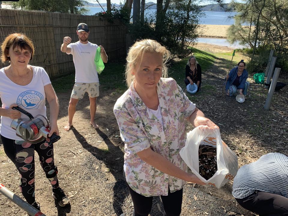 Six volunteers hold bags filled with polystyrene beans. 