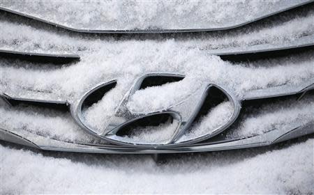 The logo of Hyundai Motor on a sedan is covered with snow at a shipping yard of South Korea's biggest automakers Hyundai Motor Co and affiliate Kia Motors Corp at a port in Pyeongtaek, south of Seoul in this January 20, 2014 file photo. REUTERS/Kim Hong-Ji/Files