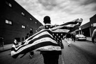 <p>Freddie Gray, a black, 25-year-old man and a resident of Baltimore's Gilmor Houses housing project, died in police custody on April 19, 2015 after being arrested days earlier for possessing a switch blade knife. His death sparked massive protests throughout Baltimore in an attempt to bring attention to the city's systemic inequality and the alleged, routine excessive force used by police. (Andrew Burton/SWPA) </p>