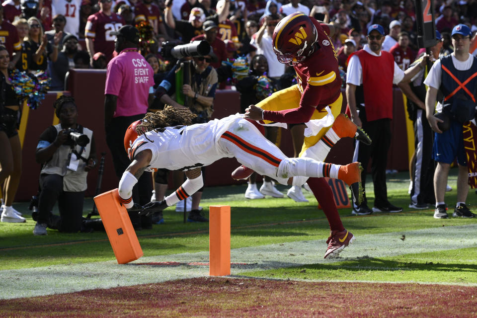 Washington Commanders quarterback Jayden Daniels, right, is knocked out of bounds by Cleveland Browns cornerback Mike Ford Jr., left, during the second half of an NFL football game in Landover, Md., Sunday, Oct. 6, 2024. (AP Photo/Nick Wass)